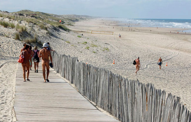 Naturyści wchodzą na plażę drewnianym pomostem